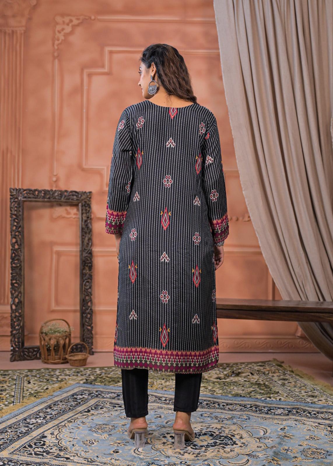 Back view of a woman wearing a black striped embroidered suit set with detailed red and white patterns