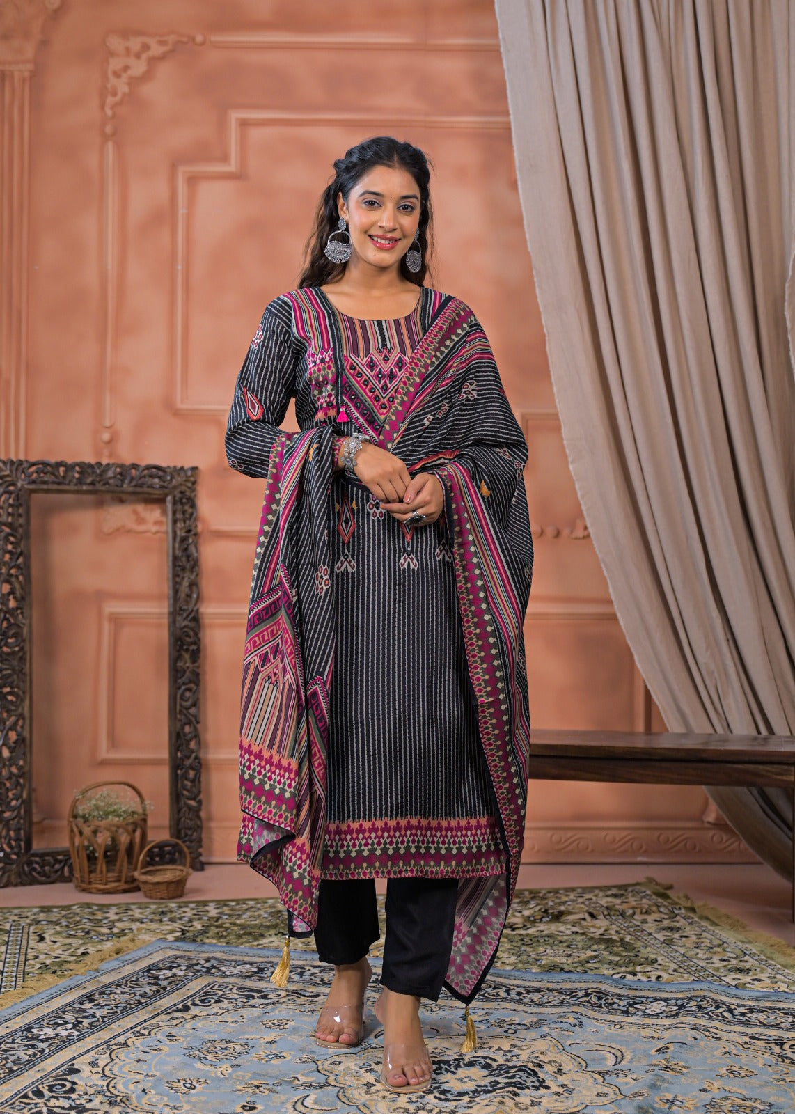 Woman wearing black striped embroidered suit set with pink detailed embroidery and matching dupatta