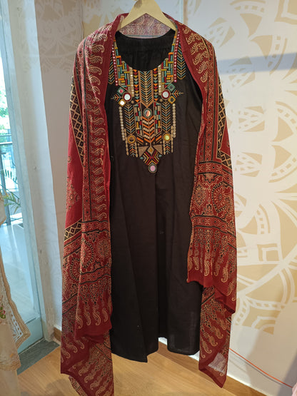 Black cotton festive suit with colorful embroidered neckline and red patterned dupatta from Dharini's Store
