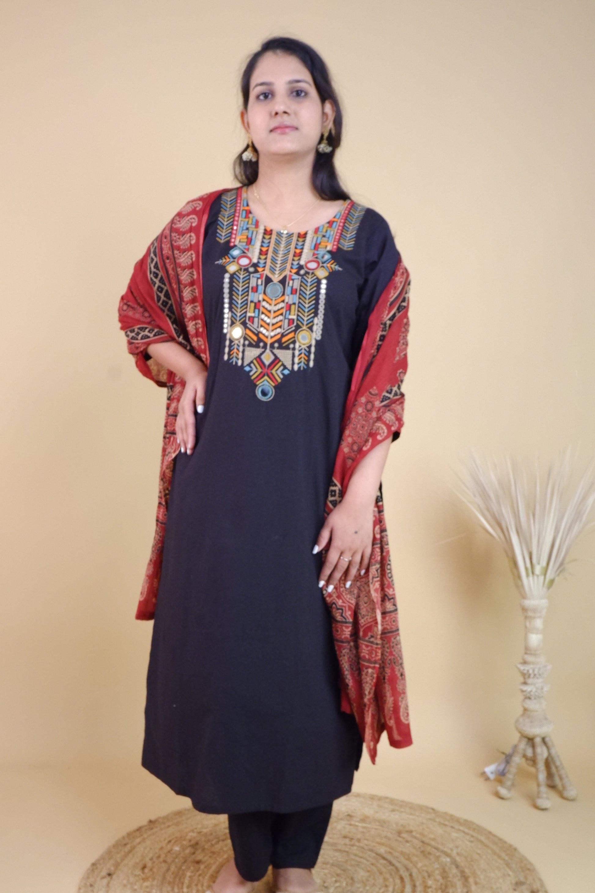 Black cotton festive suit with colorful embroidery and red patterned dupatta from Dharini's Store