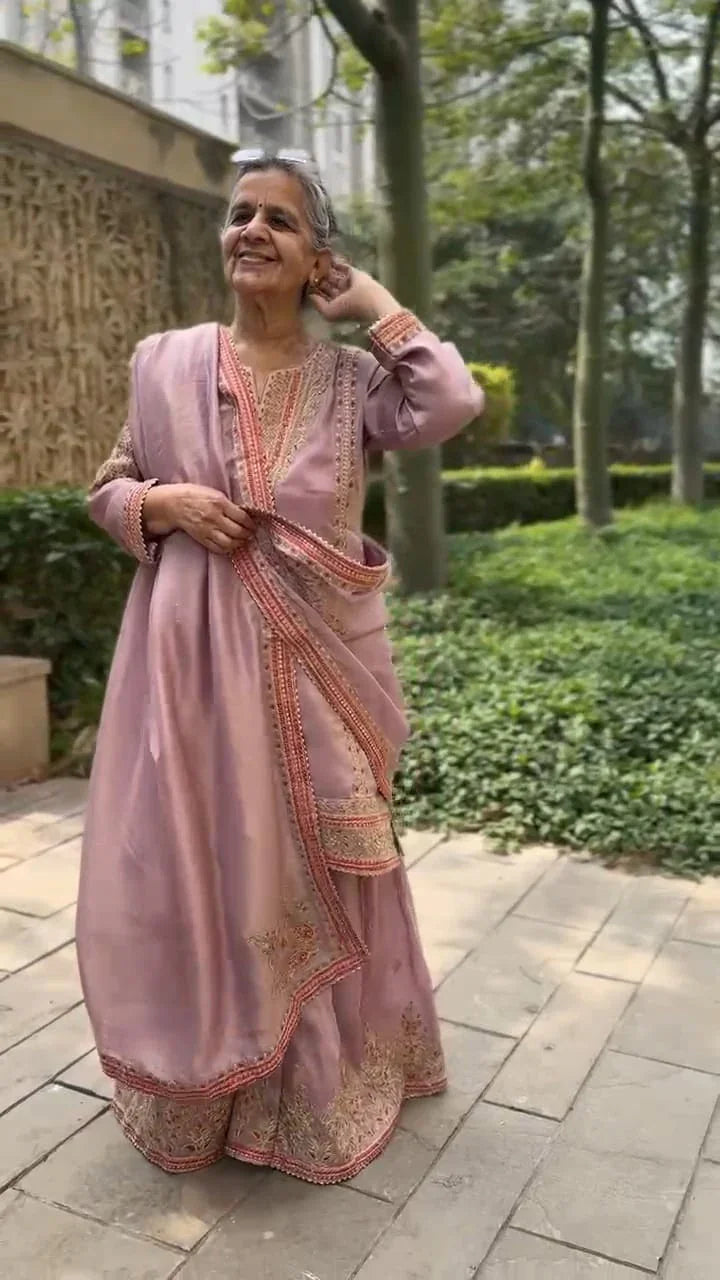 Elegant festive garara set for women in soft pink with intricate embroidery worn outdoors