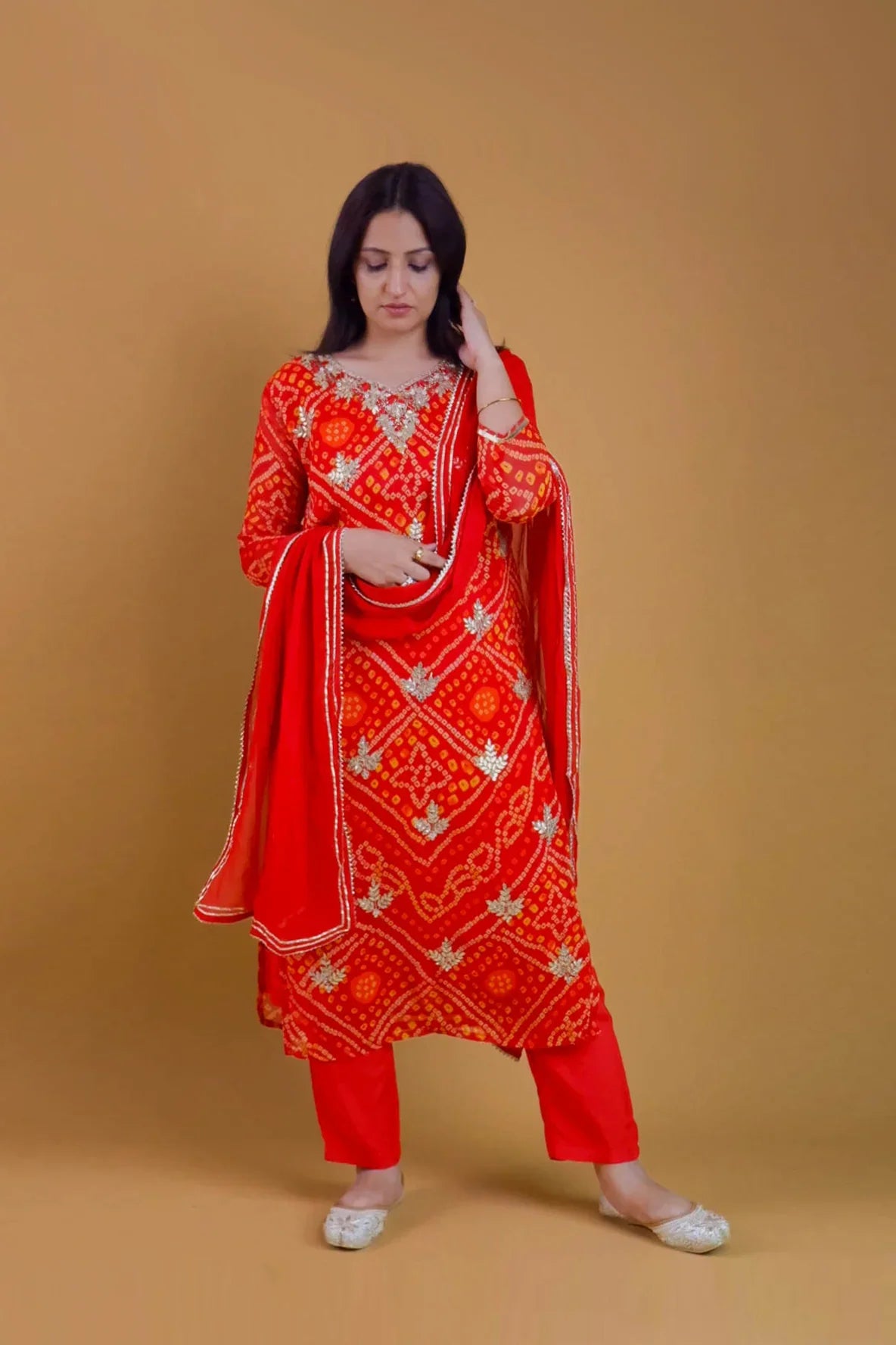 Woman wearing a red Georgette Bandhani suit online with traditional patterns and matching dupatta