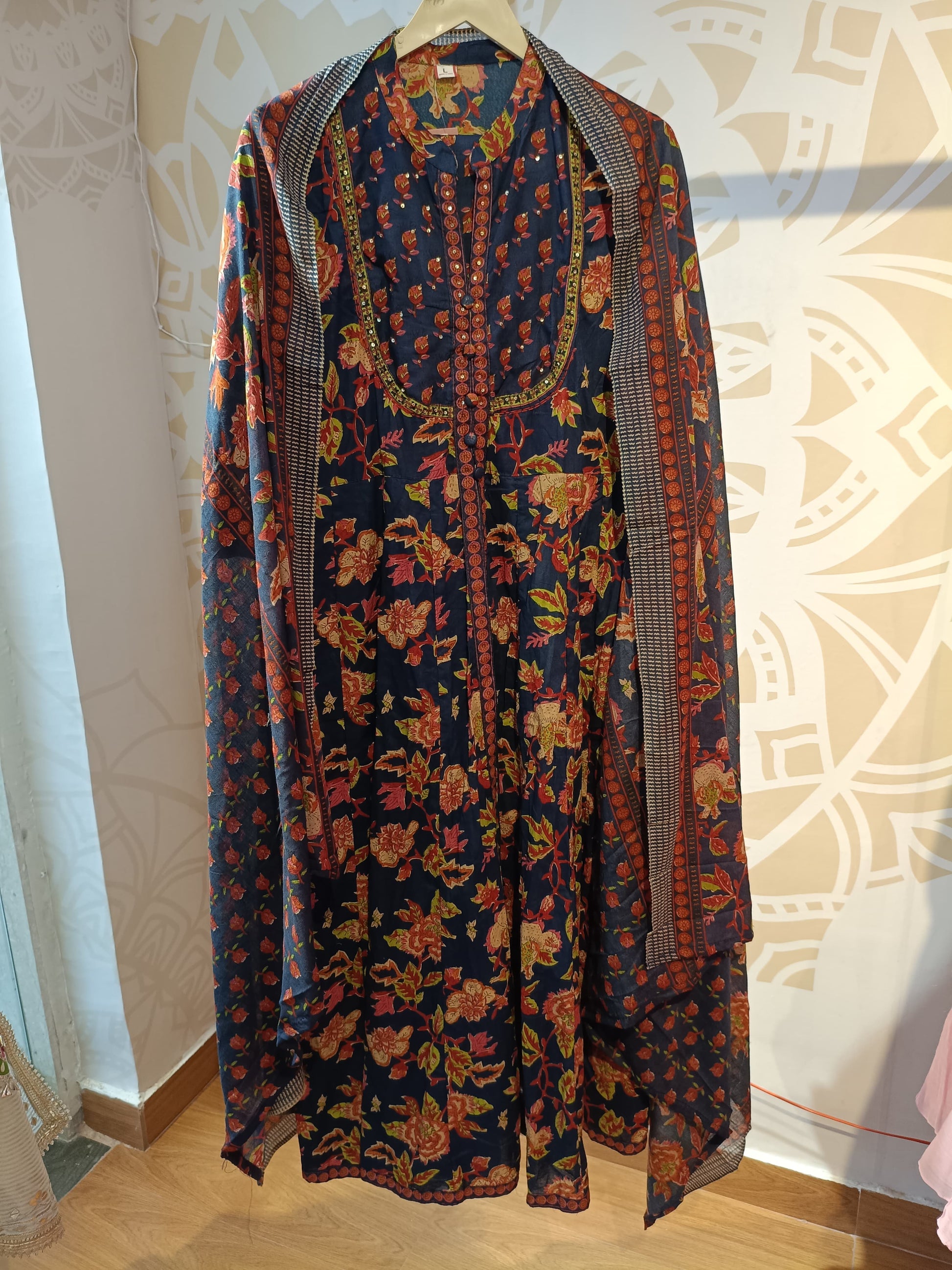 Navy floral cotton suit set with pink and orange flower patterns hanging on wooden hanger