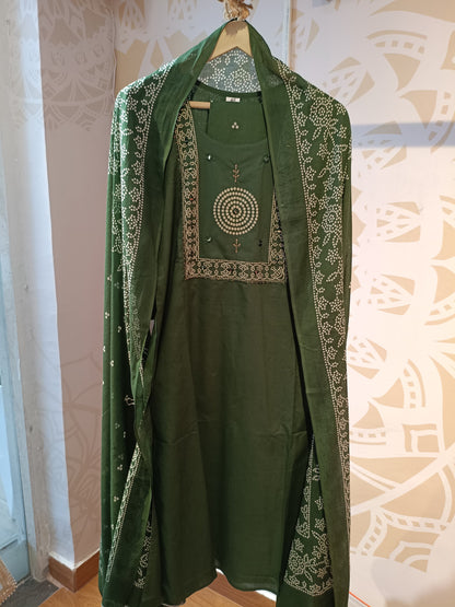 Olive green cotton suit for women displayed on a hanger with intricate white embroidery details