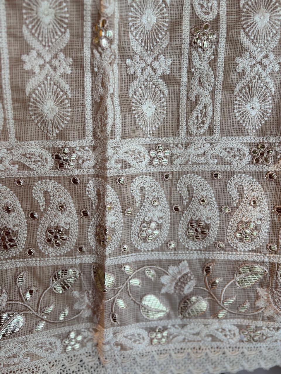 Close-up of pure cotton kota doria fabric with intricate white embroidery and mirror detailing