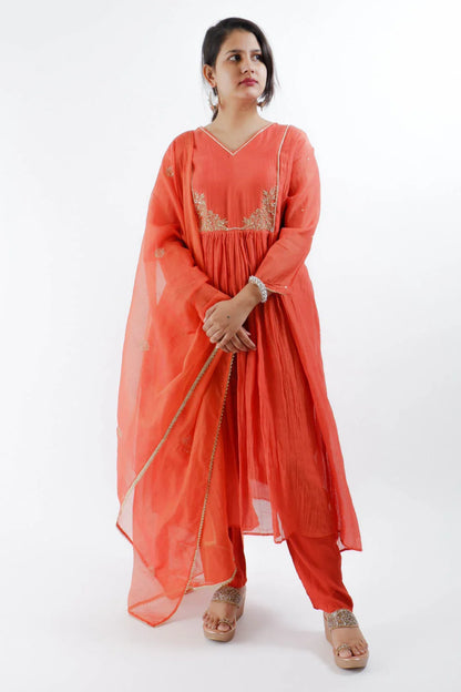 Woman wearing rust orange Chanderi suit with embroidery and sheer dupatta from Dharini's Store