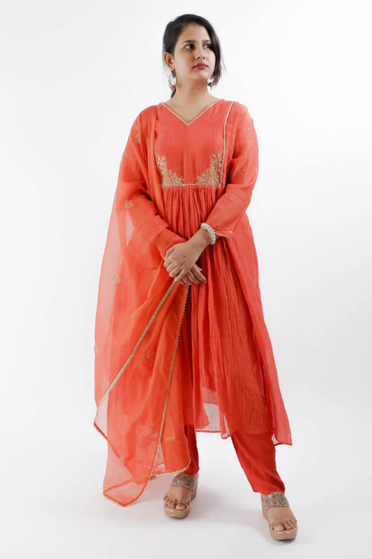 Woman wearing rust orange Chanderi suit with embroidery and sheer dupatta from Dharini's Store