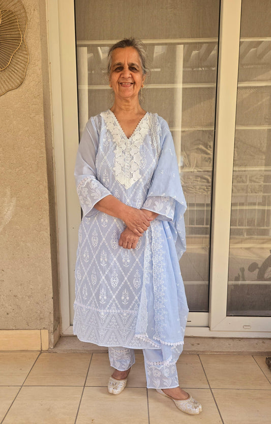 Elderly woman wearing a light blue Schiffli work straight-cut suit with white embroidery