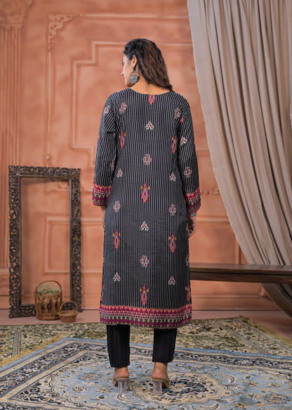 Back view of a woman wearing a black striped embroidered suit set with detailed red and white patterns