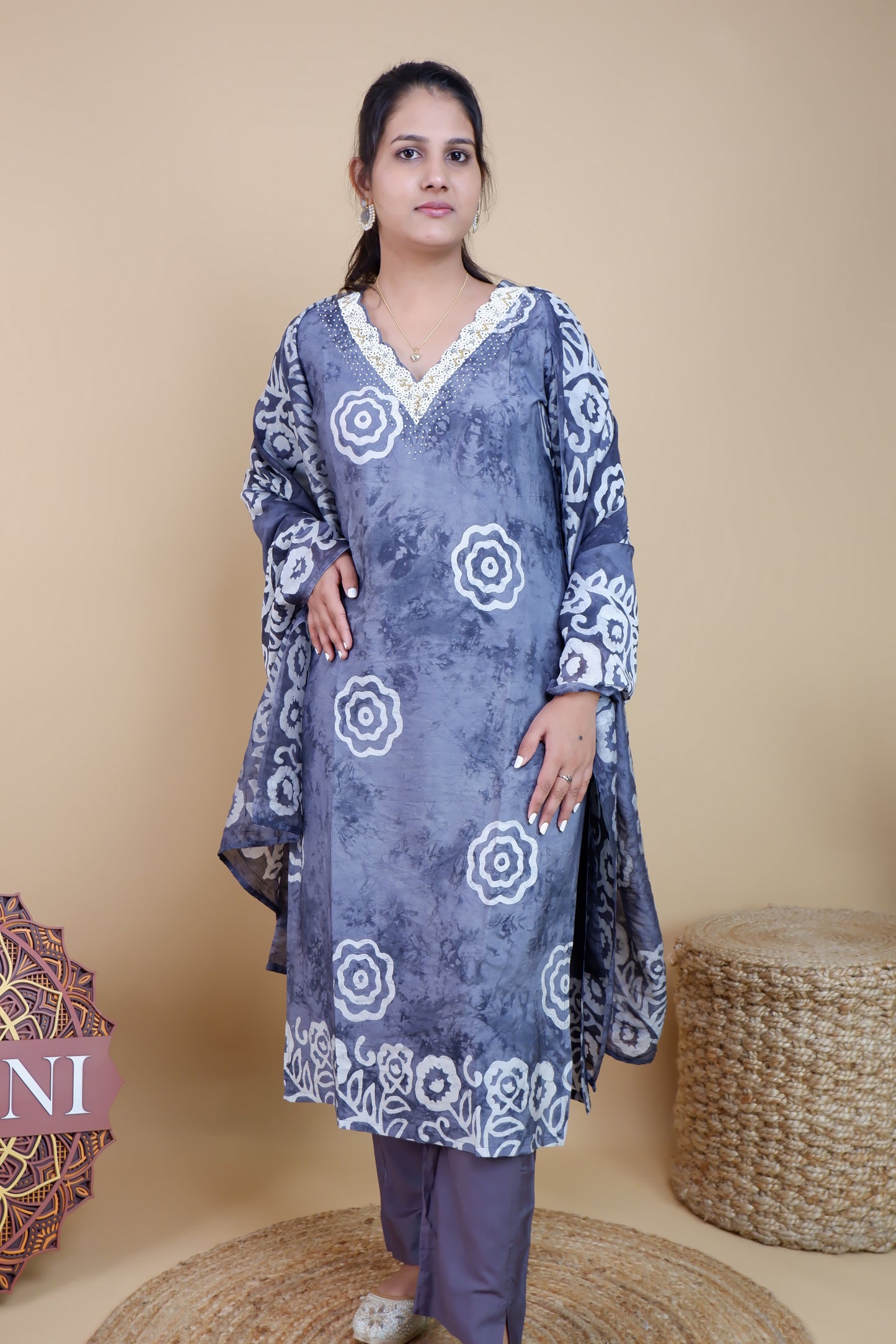 Woman wearing grey and white cotton suit set with floral patterns and lace neckline