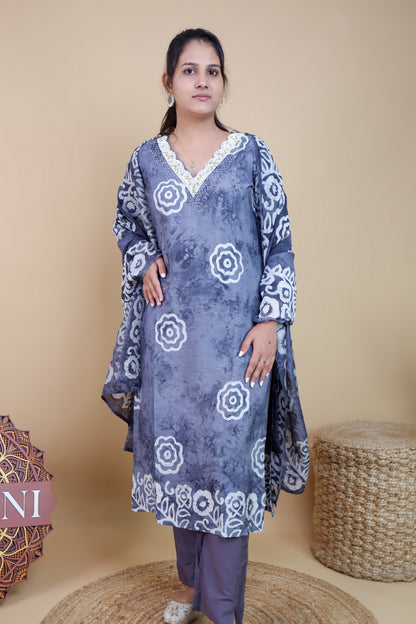 Woman wearing grey and white cotton suit set with floral patterns and lace neckline